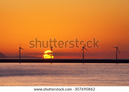 sea wind turbines at sunset