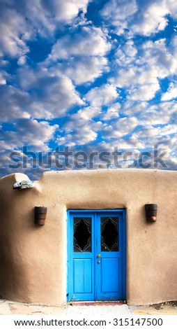 Unique blue door and a dramatic sky in Santa Fe, NM