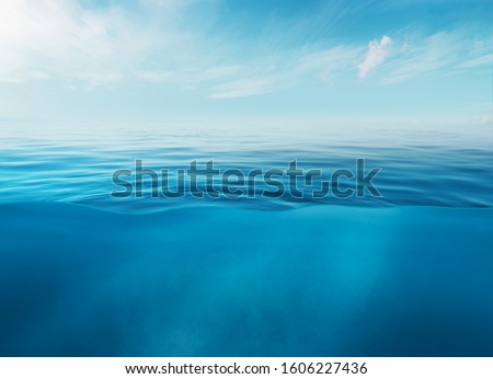 Blue sea or ocean water surface and underwater with sunny and cloudy sky