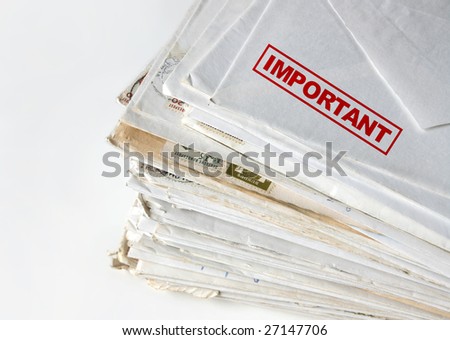 Big stack of letters and envelopes on a desk, top letter labeled as important.