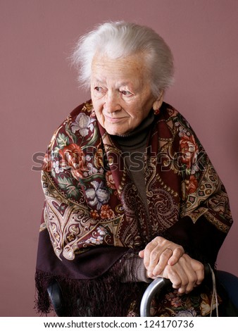 Old woman with a cane on brown background