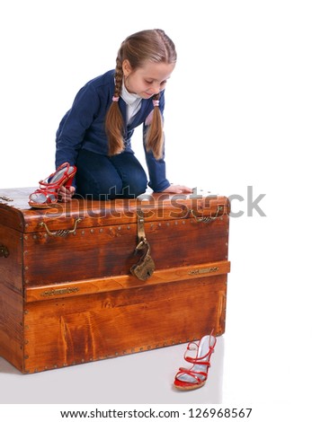 Beautiful girl sitting on big box and looking at moms shoes
