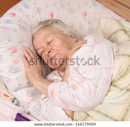 Sick senior woman lying at bed