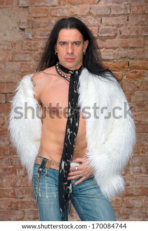 Young man with long hair in fur coat