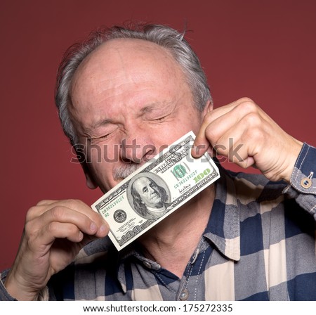 Elderly man holding with pleasure one hundred dollar bill