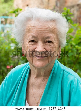 Old smiling woman on nature background