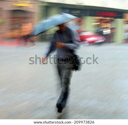 Man walking down the street on a rainy day in motion blur