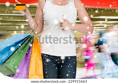 Woman holding shopping bags and credit card at shopping mall.  Christmas and holidays concept