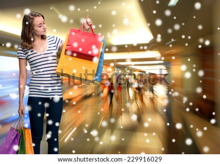 Young smiling girl with shopping bags at shopping mall.  Christmas and holidays concept