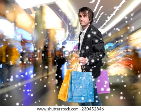 Handsome young man with shopping bags in shopping mall. Christmas and holidays concept