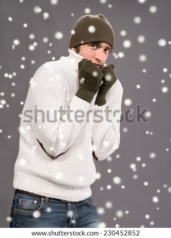 Handsome man in winter mittens and hat. Christmas and holidays concept