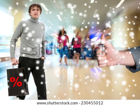 Man with shopping bag, another man gesturing thumb up at shopping mall. Christmas and holidays concept