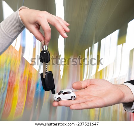 Man holding small car , woman holding  car key in auto show