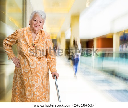 Old woman with a cane in the shopping mall