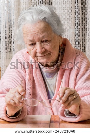 Portrait of old sad woman at home