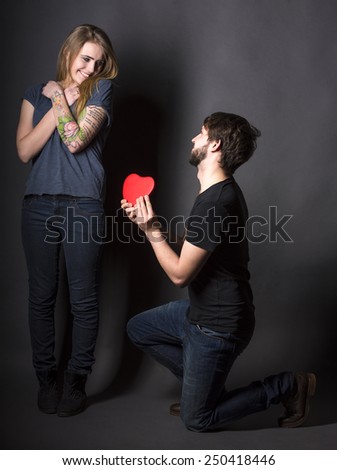 Happy couple with red heart on a dark background