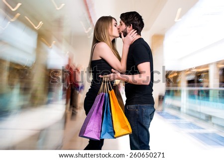 Happy couple with shopping bags in the mall