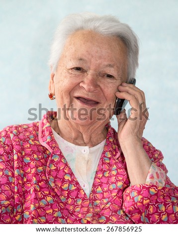 Old smiling woman talking on mobile phone