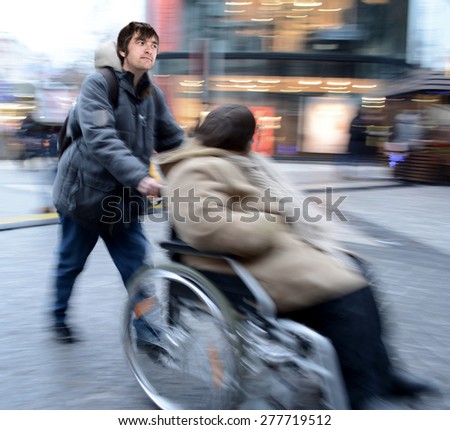 Man pushing  woman in a wheelchair in motion blur