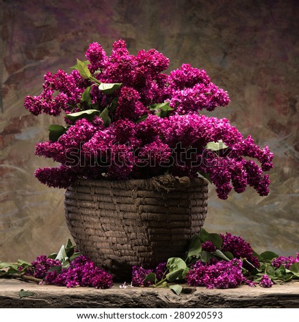 Still life with blooming branches of lilac in basket