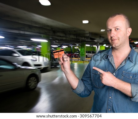 Man holding a credit card in his hand in the parking garage