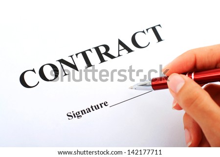 Hand with red pen and contract.