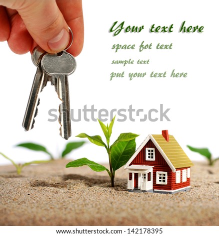 Key in hand and house isolated over white.