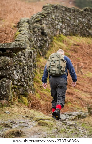 Man hiking up a mountain in Grasmere, Cumbria, England