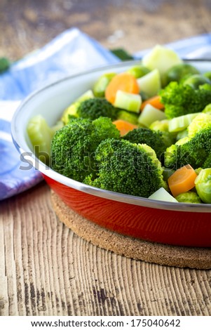 Brussels sprouts, broccoli and carrots in a pan. Rustic table