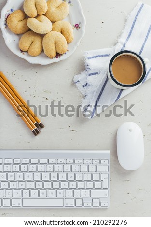 Office Desk with keyboard, mouse, coffee, cookie and pencil