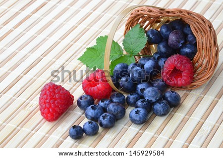Forest fruits - raspberry and blueberry in a basket.