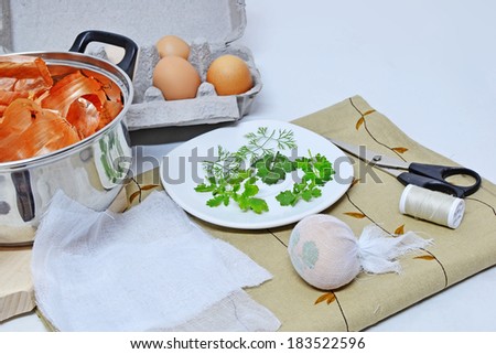 Dying Easter eggs with onion skin and green leaves.