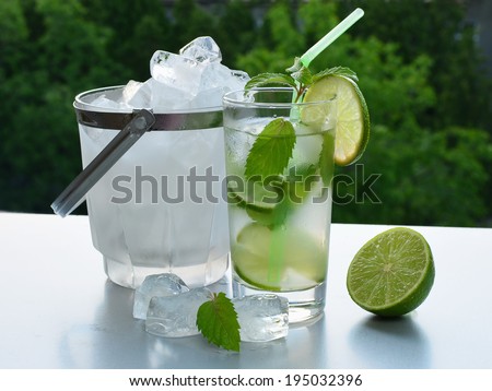 Ice cold mojito cocktail with ice cubes in glass ice bucket.