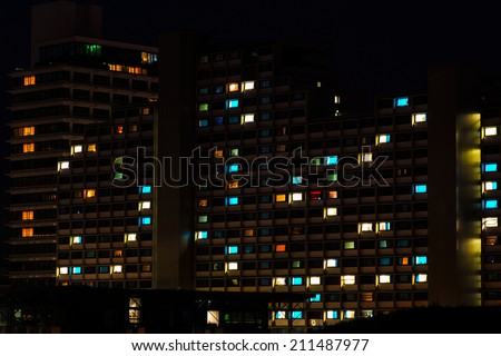Night colorful windows lights of the high-rise residential building in city sleeping area