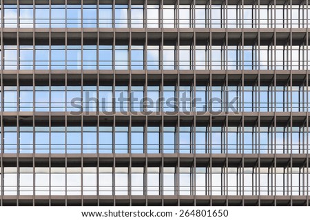 Geometrically correct architectural background of modern office building facade with blue sky and clouds reflection in windows