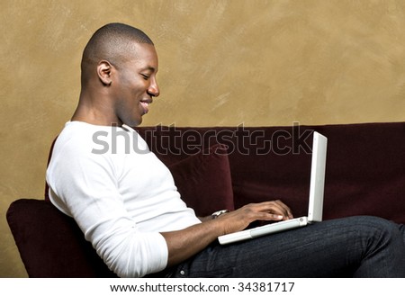 Handsome male model using laptop computer, with copy space.