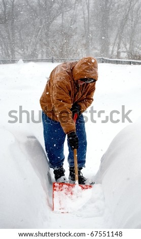 man shoveling snow in a snow storm