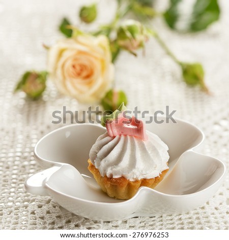 Mini cake on a white plate  and single rose