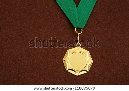 Gold medal with green ribbon on brown velveteen