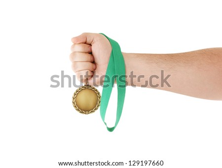 Gold medal with green ribbon in hand isolated on white