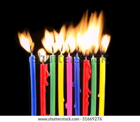 Color candles with flames on black background
