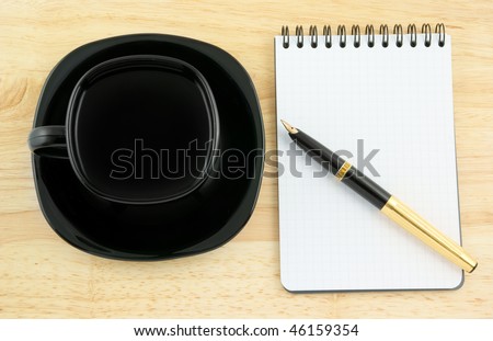 Blank pad of paper with pen and coffee on wooden background