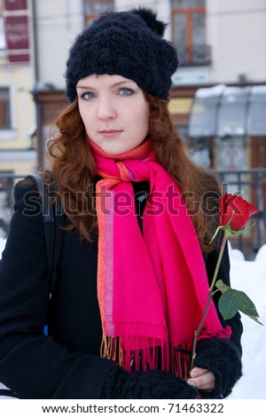 Woman with red rose in winter city