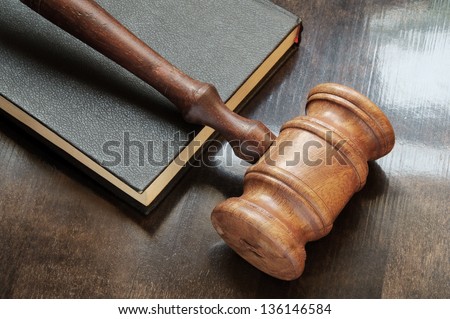 Judge\'s gavel and legal book on wooden table