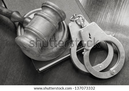 Judge\'s gavel and handcuffs on legal book