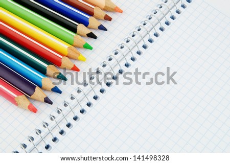 Colorful pencils on checked note paper