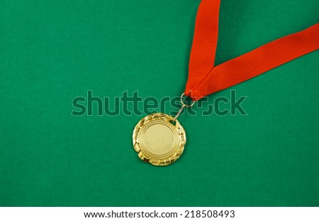 Gold medal with red ribbon on green velveteen with room for text