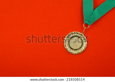 Gold medal with green ribbon on red velveteen with room for text