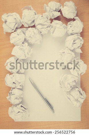 Empty paper, pen and crumpled paper on wooden table