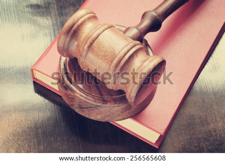 Judge\'s gavel and red legal book on wooden table